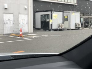 病院の駐車場からPCR検査プレハブを望む